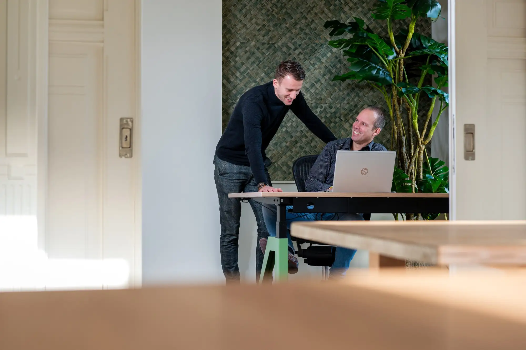Twee collega's van het Service Center overleggen bij een laptop